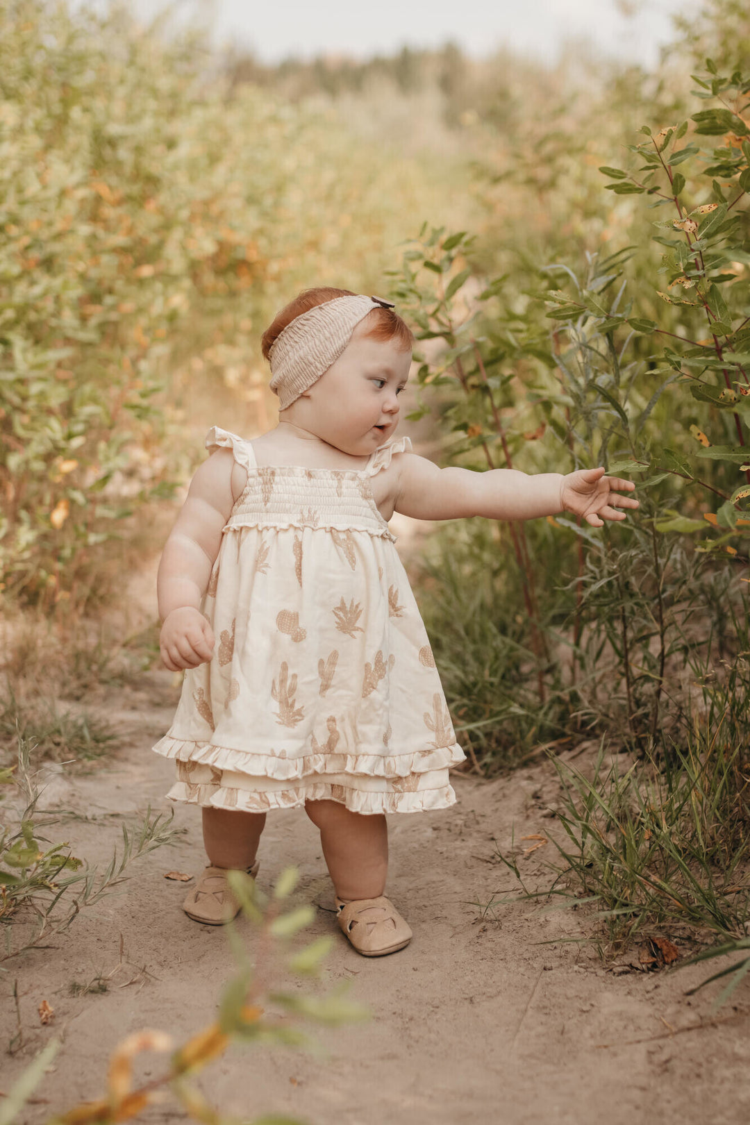Child wearing Printed Smocked Summer Dress in Buttercream Cactus.