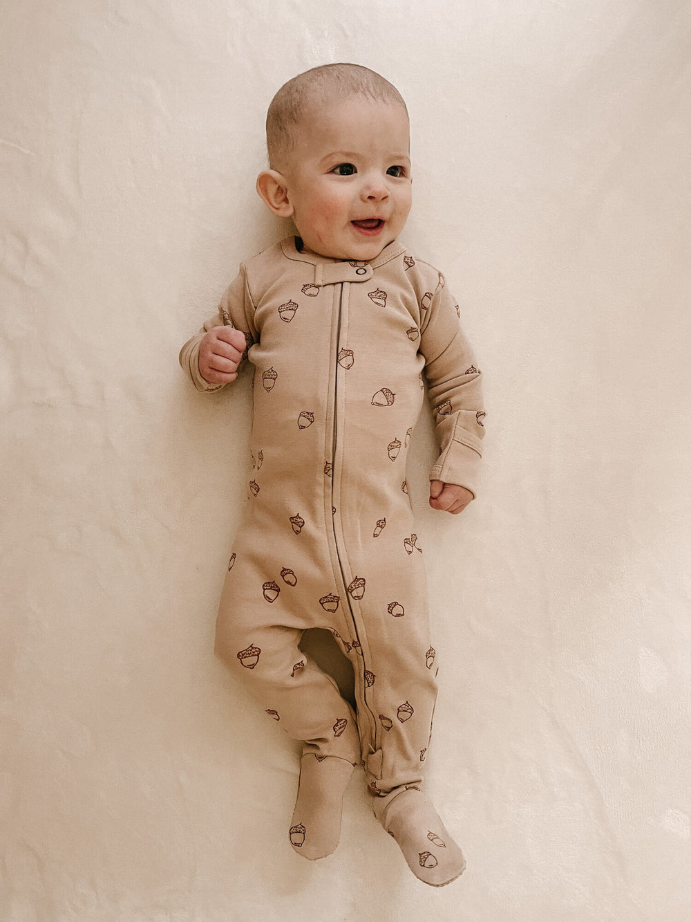 Child wearing Organic Zipper Footie, Print in Oatmeal Acorn.