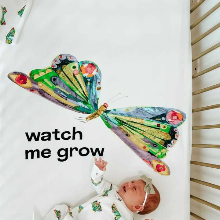 Child wearing Organic Crib Sheet 2-Pack in Watch Me Grow.