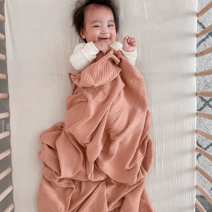 Child wearing Ribbed Blanket in Adobe.