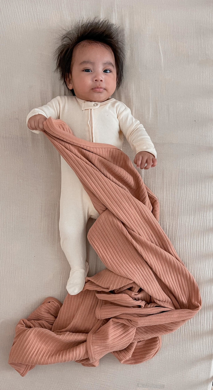 Child wearing Ribbed Blanket in Adobe.