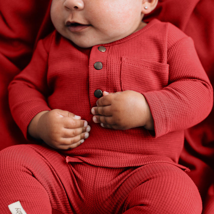 Child wearing Organic Thermal Baby Lounge Set in Cherry.