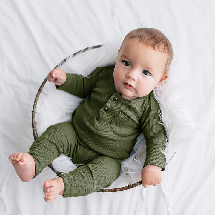 Child wearing Organic Thermal Baby Lounge Set in Forest.
