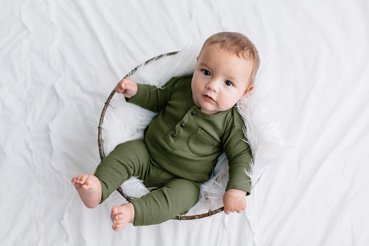 Child wearing Organic Thermal Baby Lounge Set in Forest.
