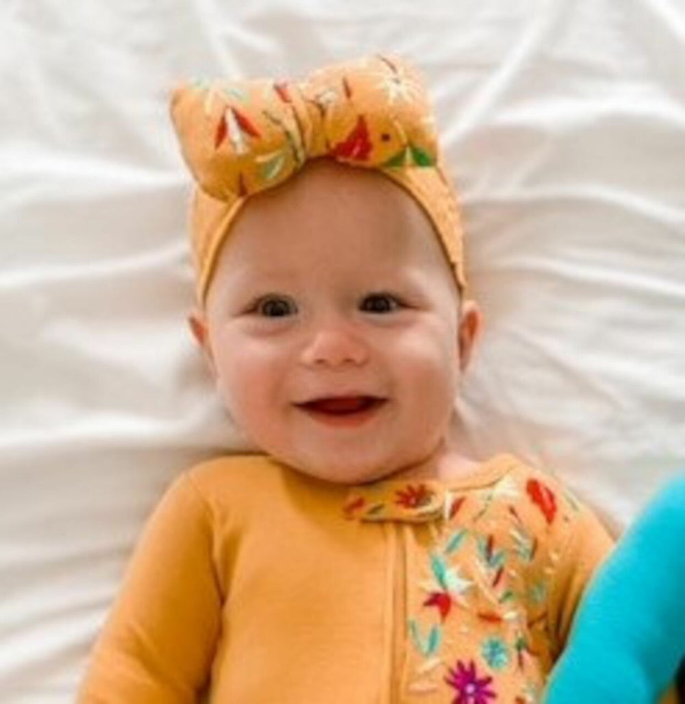 Child wearing Embroidered Bowtie Headband in Tangerine Floral.