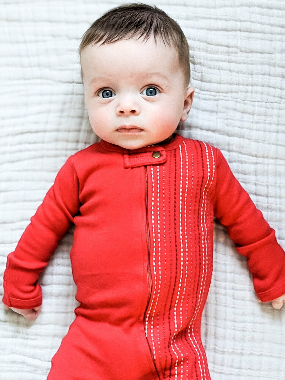 Child wearing Embroidered Zipper Footie in Chili Pepper Dash.