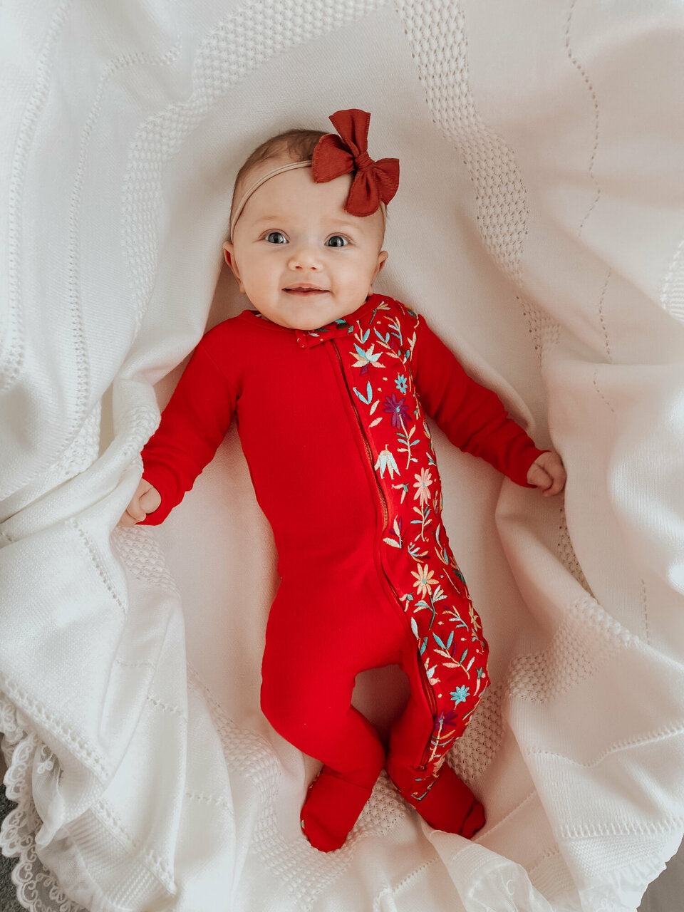 Child wearing Embroidered Zipper Footie in Chili Pepper Floral.