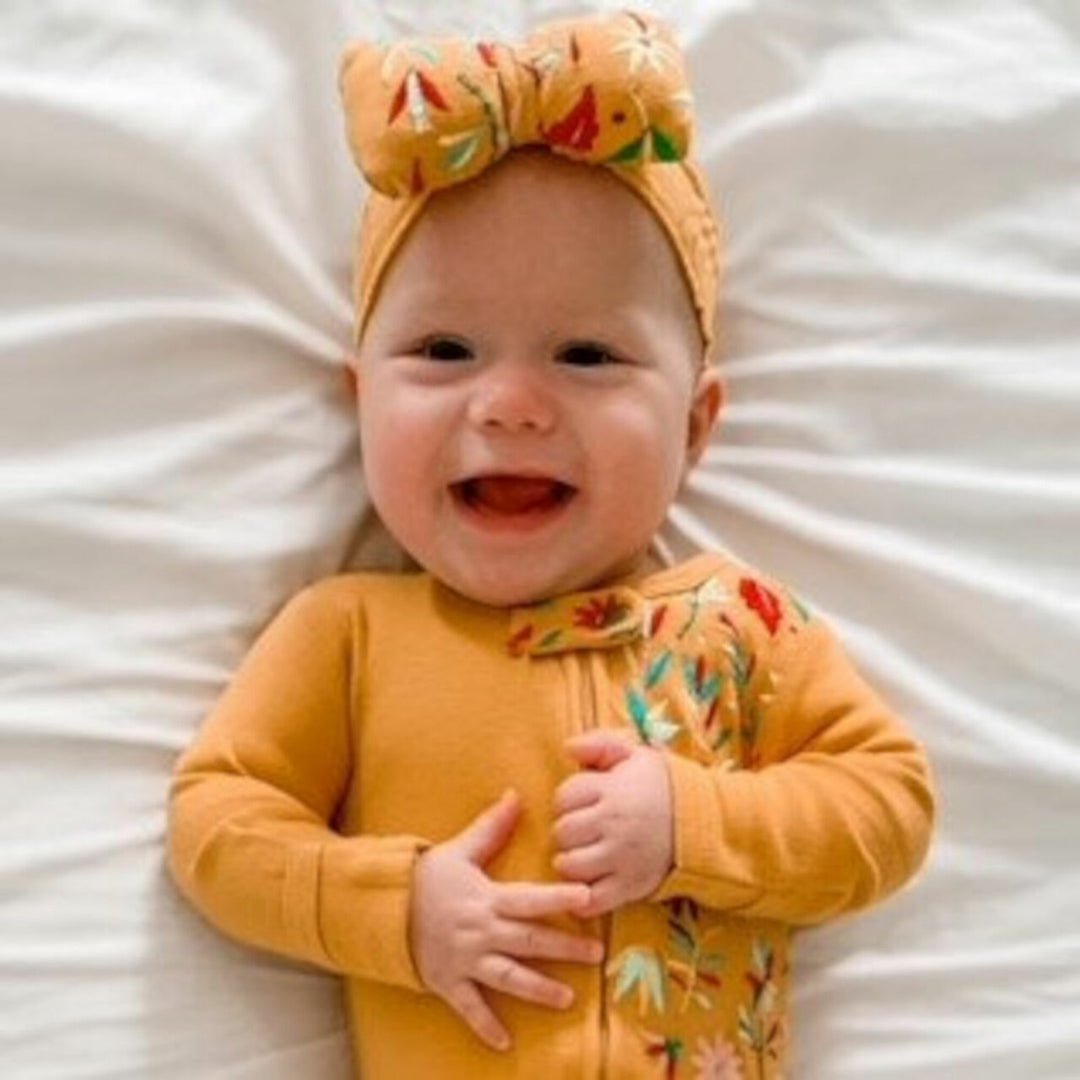 Child wearing Embroidered Bowtie Headband in Tangerine Floral.