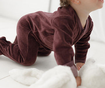 Child wearing Organic Velour Footed Overall in Eggplant.