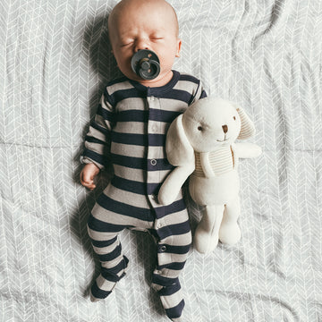 Child wearing Organic Snap Footie in Navy/Light Gray Stripe. Credit: @some_assembly_required__