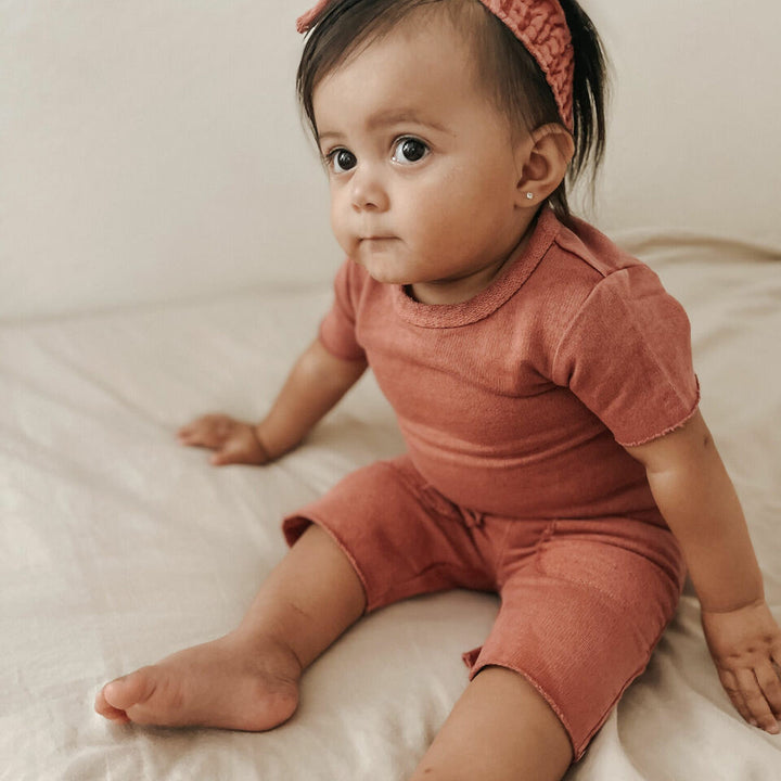 Child wearing French Terry Smocked Headband in Sienna.