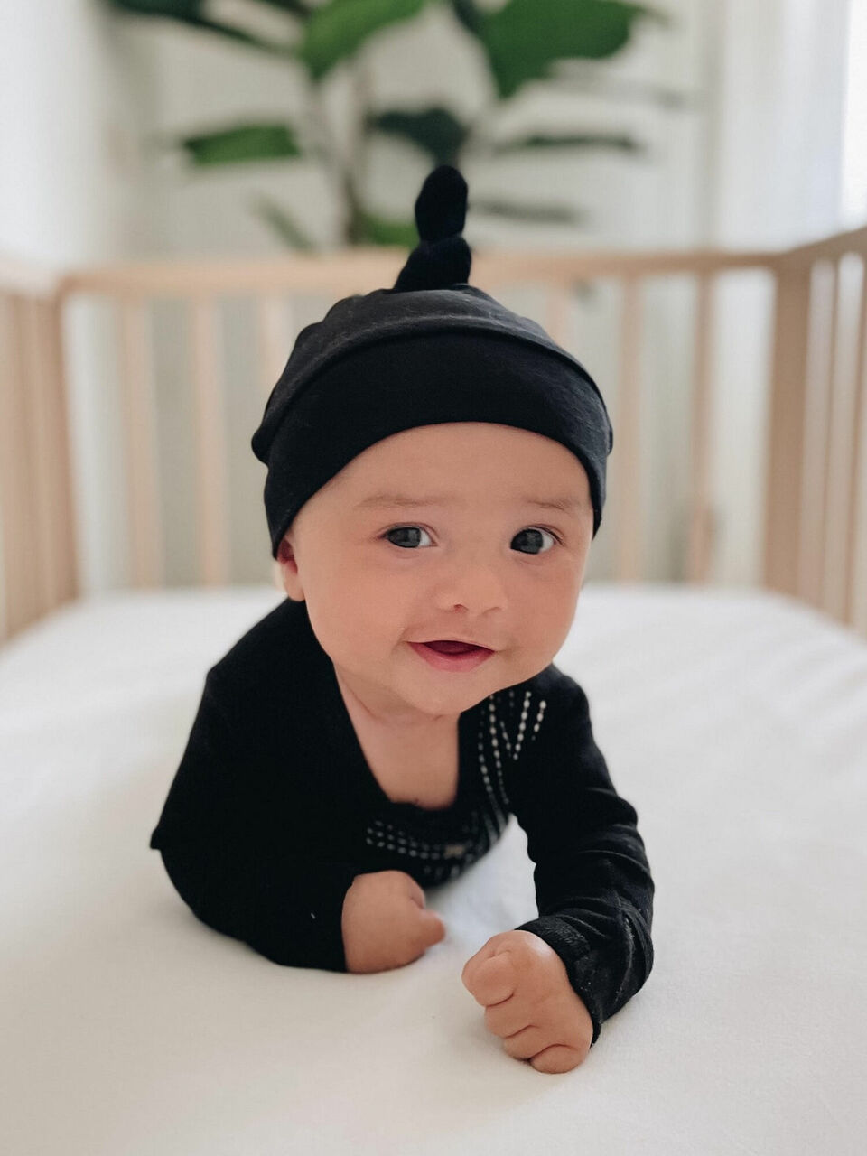 Child wearing Organic Banded Top-Knot Hat in Black.