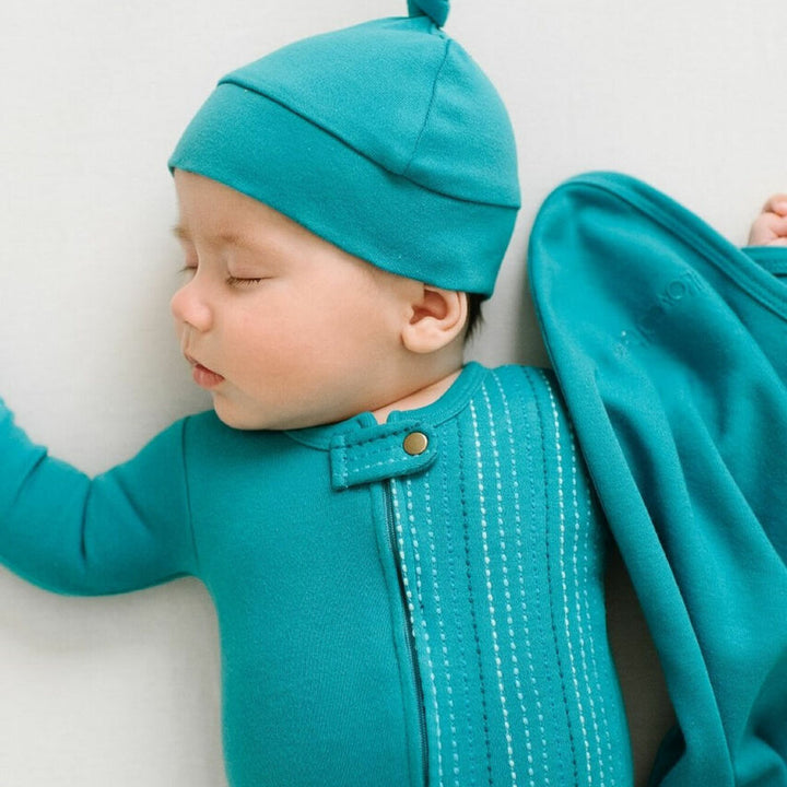 Child wearing Embroidered Zipper Footie in Teal Dash.