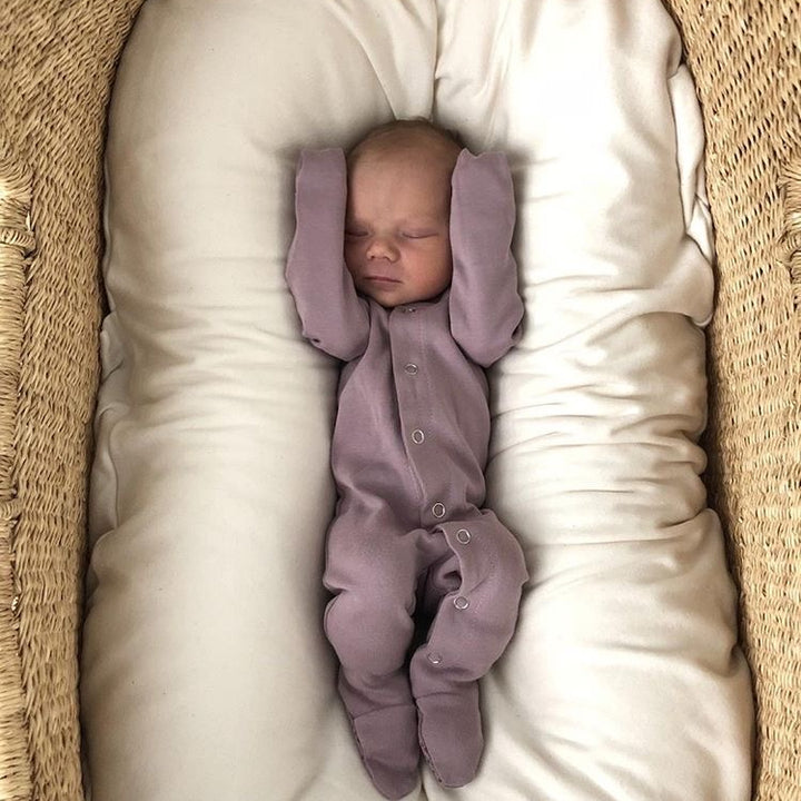 Child wearing Organic Snap Footie in Lavender.