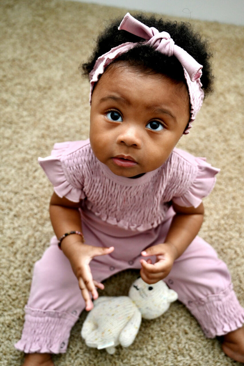 Child wearing Smocked S/Sleeve Romper in Blossom.