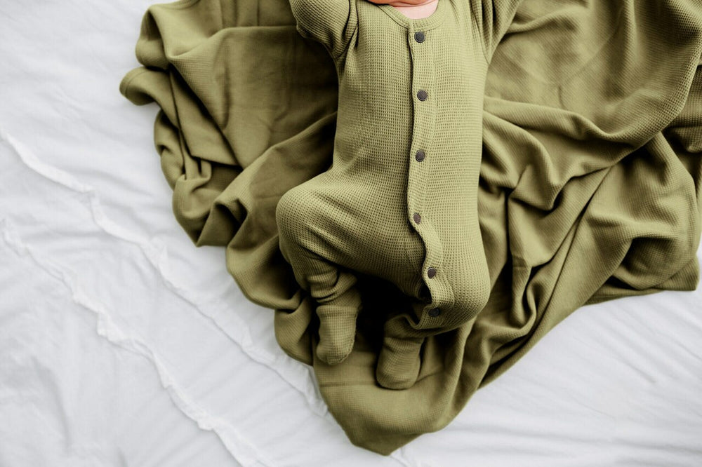 Child wearing Organic Thermal Swaddling Blanket in Sage