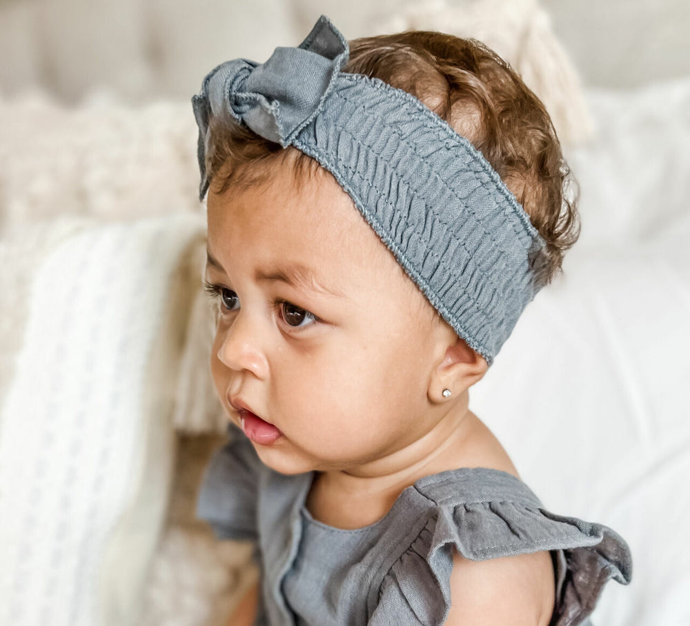 Child wearing Muslin Smocked Headband in Moonstone.