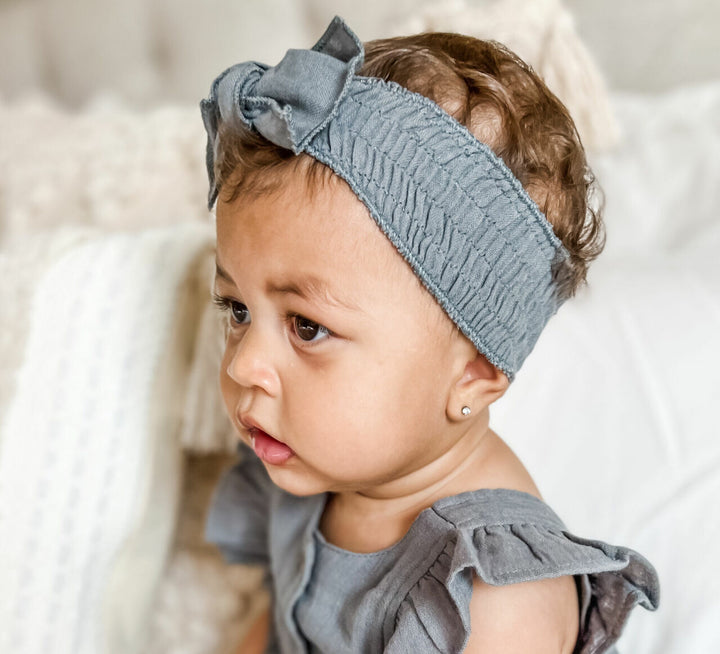 Child wearing Muslin Smocked Headband in Moonstone.