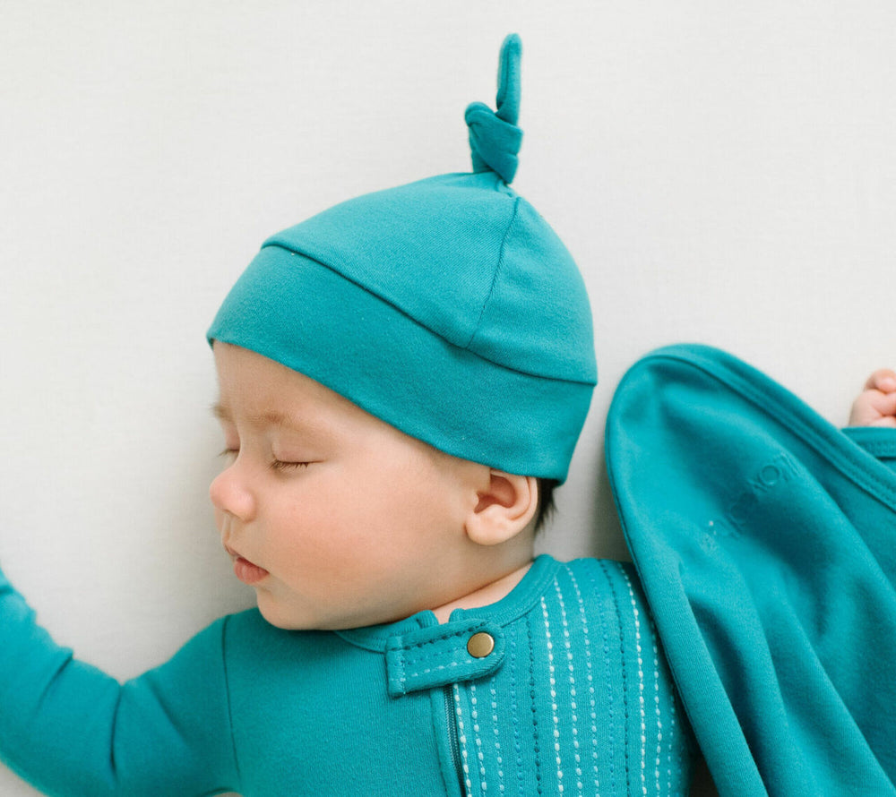 Child wearing Organic Banded Top-Knot Hat in Teal.