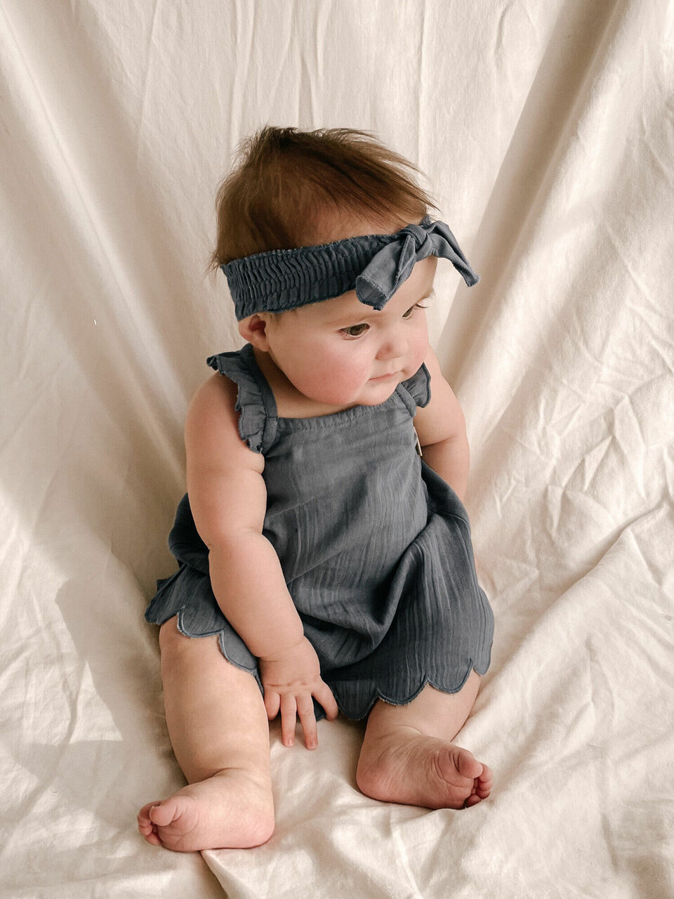 Child wearing Muslin Smocked Headband in Moonstone.