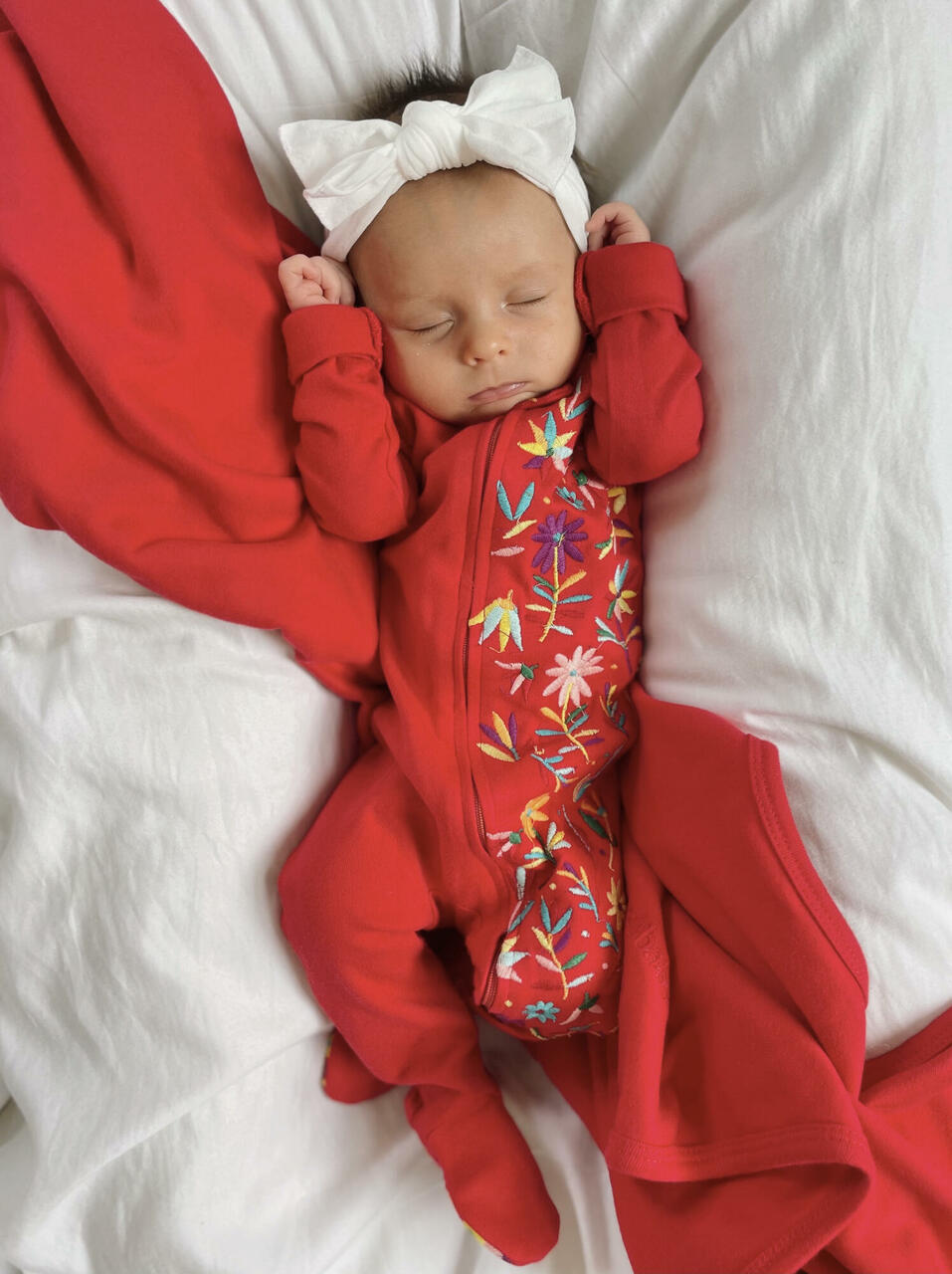 Child wearing Organic Swaddling Blanket in Chili Pepper.