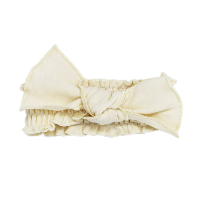 Organic Smocked Tie Headband in Buttercream, a light beige color.