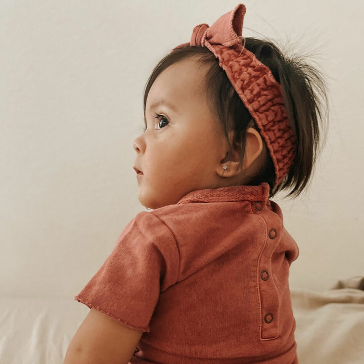 Child wearing French Terry Smocked Headband in Sienna.