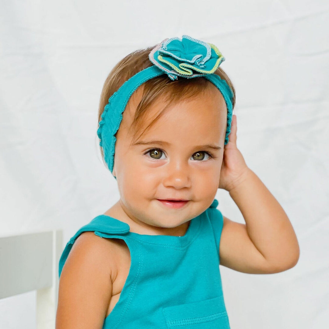 Child wearing Embroidered Flower Headband in Teal.