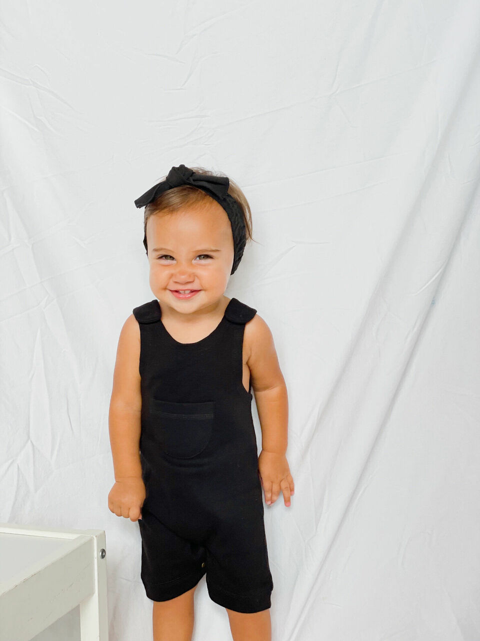 Child wearing Organic Kids' Sleeveless Romper in Black.