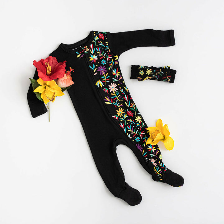 Child wearing Embroidered Zipper Footie in Black Floral.