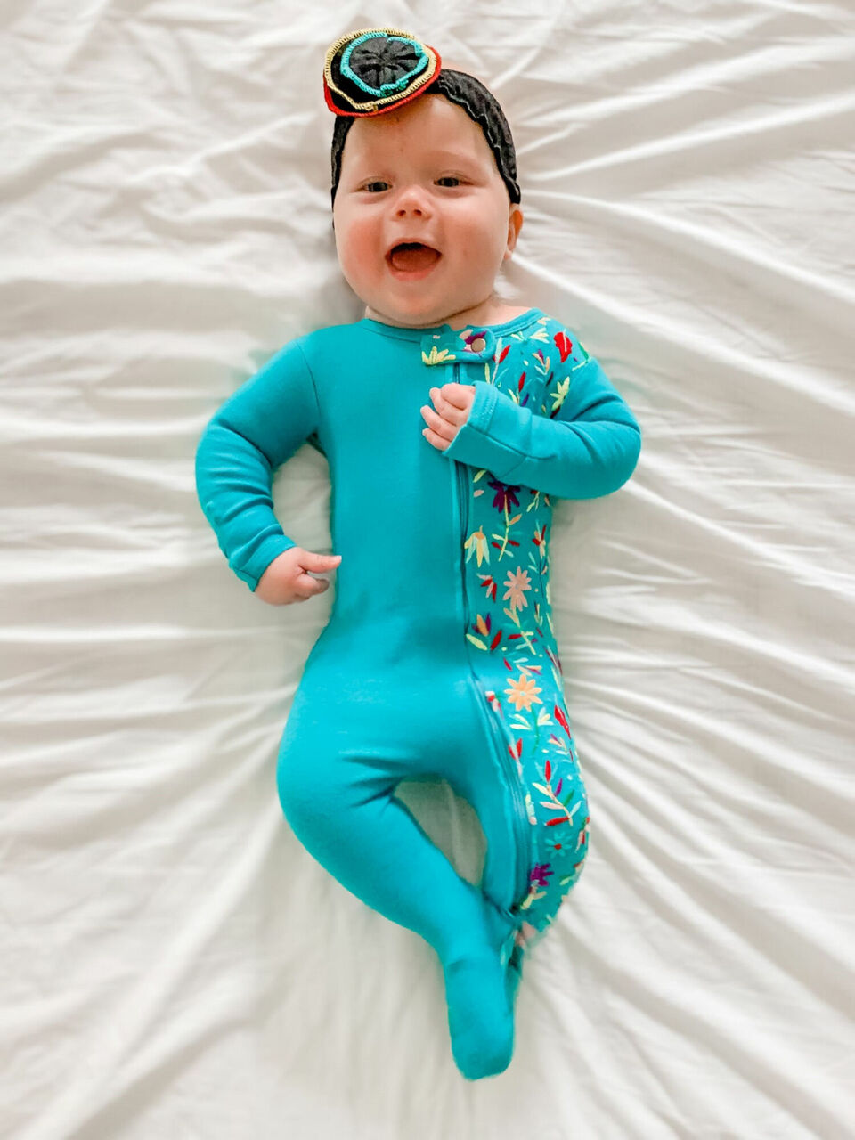 Child wearing Embroidered Zipper Footie in Teal Floral.