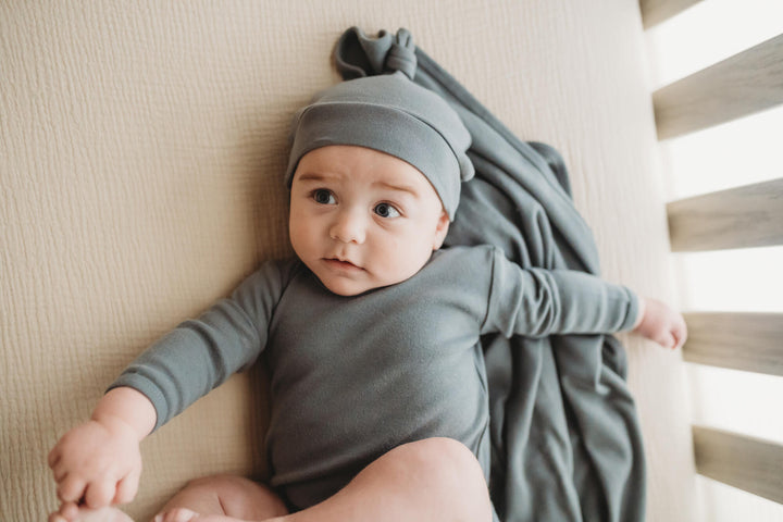 Child wearing Organic Banded Top-Knot Hat in Moonstone.
